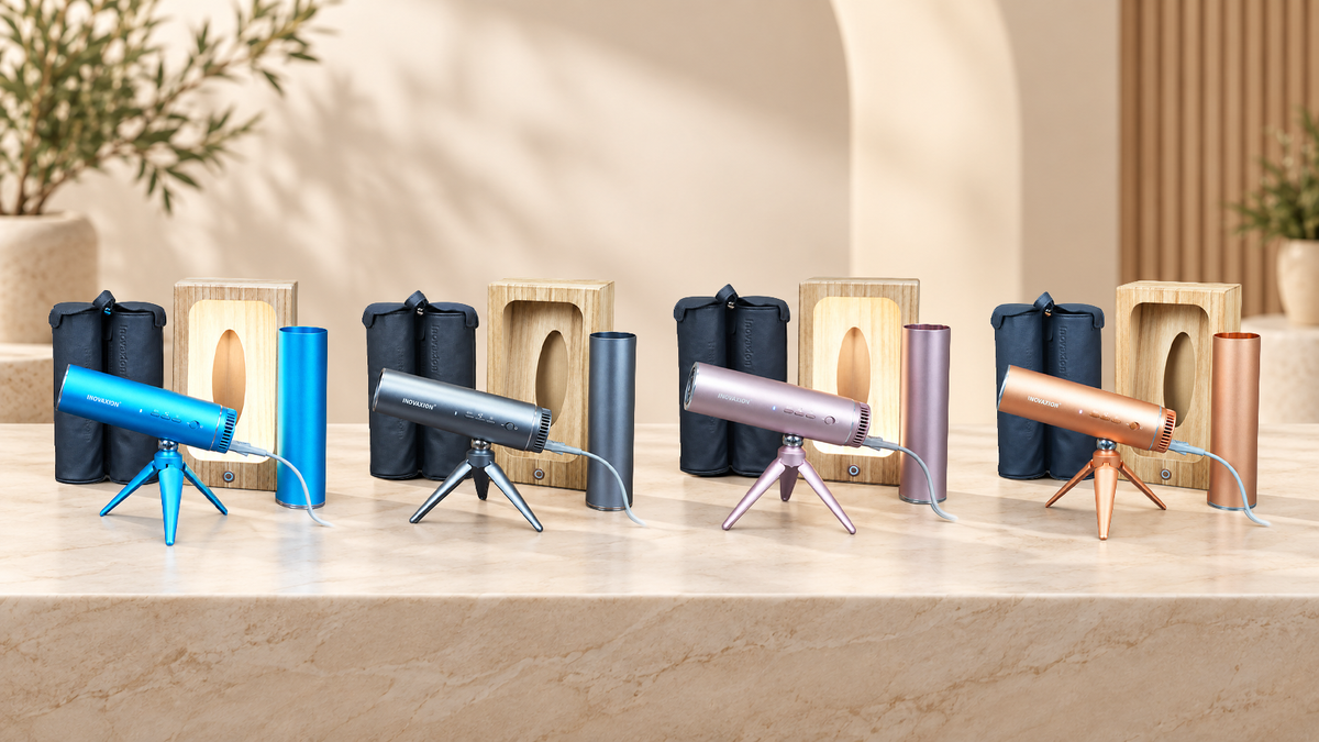 Das LeLunar HandsFreeDryer Set in Bondi Blue, Space Grey, Sunset Rose und Amber Gold: Föhn, Klappstativ, Wandhalterung und Reise-Kapsel, auf einer Marmorplatte